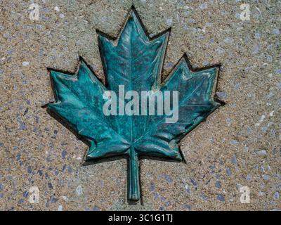 Ein kupferfarbenes Meaple Leaf, Emblem Kanadas auf einem Stein Stockfoto