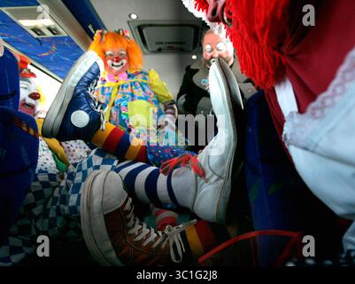 Februar 2006; St. Cloud, USA; St. Paul Clown Club-Mitglieder Bob Klund „Jinxie“, von links nach rechts, Colleen Charles „Penilopeee“, Dennis Carter „Bubbles“ und Denise Chapen, „Sassie“, vergleichen Clownschuhe, während Mitglieder des Clubs und andere Entertainer mit dem Bus zum St. Cloud Veteran's Administration Medical Center fahren, wo sie am Samstag, dem 12. Februar, 2005, Tierärzte besuchten. Clowns und andere Entertainer machen seit etwa 30 Jahren die jährliche Wanderung nach St. Cloud, um Tierärzte zu unterhalten. Der St. Paul Clown Club ist die älteste Clownorganisation des Landes Stockfoto