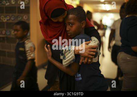 29. Juni 2017 - St. Paul, MN, USA - Shukri Abdul, umarmte ihren Sohn Yahya, 12, als sie ihn am Donnerstagnachmittag aus dem Erholungszentrum in der Nachbarschaft abholte, wo er und seine Schwestern den Tag verbrachten. Shukri Abdul, eine alleinerziehende fünfköpfige Mutter aus St. Paul, fliegt am Montag nach Malaysia, um bei ihrer Verlobten zu sein. Weil die Trump-Regierung heute Morgen angekündigt hat, dass Verlobte von US-Bürgern keine "gutgläubige Beziehung" haben, ist sie besorgt, dass ihre Verlobte, die Somali ist, möglicherweise kein Visum bekommen kann. Sie wurde Donnerstag nach dem Tod in ihrem Stadthaus St. Paul fotografiert Stockfoto