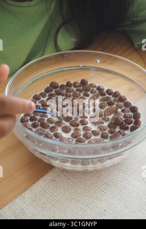 Zu Hause Müsli mit Milch in einer Schüssel essen Stockfoto