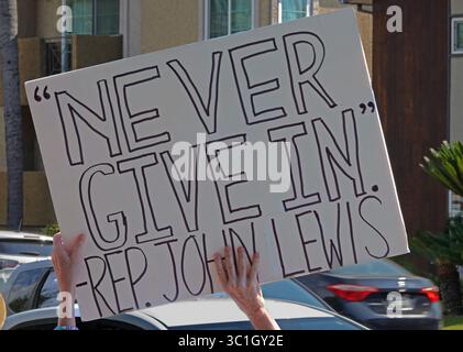 Burbank, Kalifornien, USA - 17. Juli 2025: Ein handgefertigtes Schild zitiert den ehemaligen Bürgerrechtsaktivisten und US-Repräsentanten John Lewis mit der Aufschrift „NEVER GIVE IN“. Stockfoto
