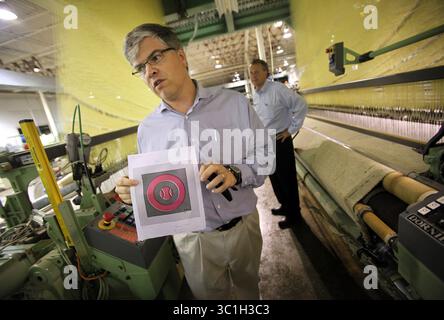18. Juli 2011: Faribault, MN, USA, von links haben Cousins Paul und Chuck Mooty die geschlossene Faribault Woolen Mill gekauft und planen, sie bald wieder zu eröffnen. Sie standen zwischen zwei Webstühlen, die bei der Betriebsstilllegung 2009 während einer Besichtigung des historischen Gebäudes in Faribault, Minn., am Montag, den 18. Juli 2011 gestoppt wurden. Paul hat ein Muster, an dem die Mühle arbeitete, eine Baseballdecke der Zwillinge. (/STAR TRIBUNE) Paul Mooty, Chuck Mooty (Kreditbild: Renee Jones Schneider/Minneapolis Star Tribune/TNS via ZUMA Wire) Stockfoto