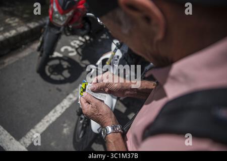 November 2018 - 27112018. San JosÃÂ, Costa Rica. INS, visita al Instituto Nacional de Seguros para observar el como va el cobro del Marchamo 2019. EN la Foto: Francisco Badilla Rivera, Le pega el marchamo que acaba de pagar a la Moto. FotografÃÂ­a: Alejandro Gamboa Madrigal (Foto: © La Nacion Via ZUMA Press) Stockfoto