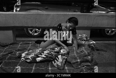 2. Juli 2018: Matamoros, Mexiko – Ingrid Perdomo, 18 Jahre alt, und ihr einjähriger Sohn Jose Luis schlafen mit anderen Asylsuchenden auf der Gateway International Bridge und warten darauf, am 2. Juli von Mexiko aus in die USA zu überqueren. Sie kam mit ihrem Gefährten Luis Miguel, 32 Jahre alt, aus Honduras, wo sie die schwierige 3-monatige Reise machten. Er sagte, er floh vor Angst und weinte viel vor Angst über seine Vergangenheit. Seine Ex-Frau fing an, mit einem Bandenmitglied auszugehen, und die Gang zündete sein Haus an und tötete seine beiden Kinder darin. Er floh in die Berge, um Sicherheit zu suchen, wo er Ingrid traf und sie ein weiteres Kind hatten. Wenn sie anfangen Stockfoto