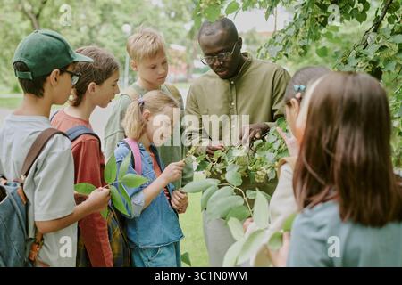 Multiethnische Schullehrer, die Gruppe von Kindern, die die Natur im Freien erkunden Stockfoto