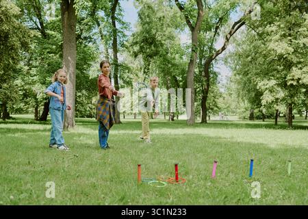 Gruppe kaukasischer Kinder, die im Park Freiluftspiel spielen Stockfoto