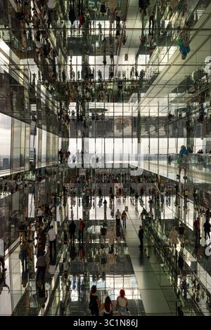 New York, USA - 06. Juni 2024: Blick auf die geschäftigen Menschenmassen spiegelt sich unendlich in den Spiegelflächen der Halle des Summit One Vanderbilt, cre Stockfoto