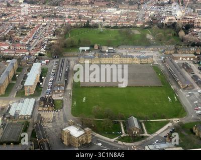 Aus der Vogelperspektive auf das weitläufige grüne Feld trifft auf strukturierte Gebäude, während das Wohngebiet in den Horizont eintaucht, Beaversfield Park (oben) Catterick, Großbritannien. Stockfoto