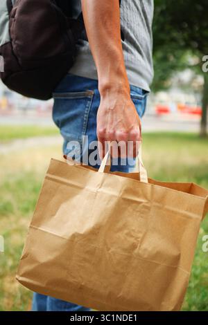 Lebensmittelgeschäft mit wiederverwendbarer Papiertüte ECO Choice, Nahaufnahme auf der Hand und brauner Tasche Stockfoto