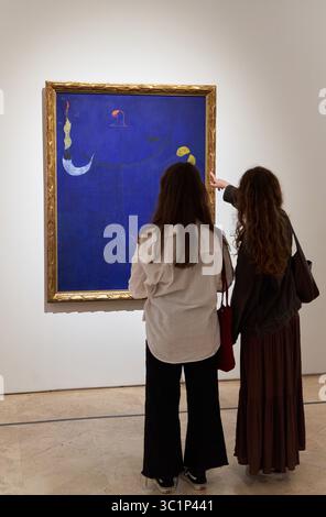 Katalanischer Bauer mit Gitarre, 1924, Joan Miró (Barcelona, 1893-Palma de Mallorca, 1983), zwei Frauen, die sich ein Gemälde ansehen, Thyssen Bornemisza Museum, Madrid, Spanien. Stockfoto