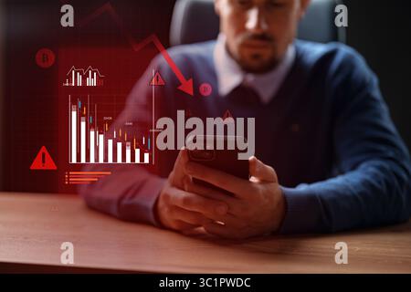 Mann analysiert Markttrends für Kryptowährungen auf Mobilgeräten während einer Phase des finanziellen Abschwungs Stockfoto