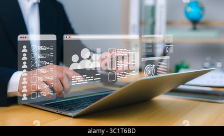 Personalbeschaffung und Personalmanagement werden über einen digitalen Workflow auf einem Laptop mit holografischen Checklisten, Benutzerprofilen und Zielsymbolen für CRM und Aufgabenautomatik verbessert Stockfoto