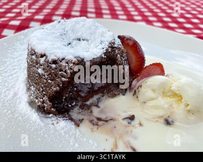 Französisches Dessert Schokoladenfondant mit Erdbeeren und Eis Stockfoto