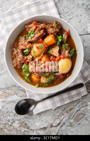 Indonesischer gewürzter Rindereintopf Semur Daging Nahaufnahme in der Schüssel auf dem Tisch. Vertikale Draufsicht von oben Stockfoto