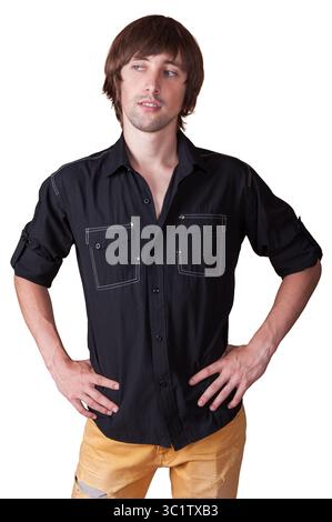 Ein junger Mann posiert entspannt und zeigt ein trendiges Outfit und Charme. Stockfoto