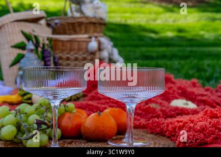 Ein lebhaftes Picknick im Herbst bietet farbenfrohe saisonale Speisen – helle Kürbisse, Äpfel, Wurstwaren, frisches Brot, Käse, und warme Getränke. Umschlossen b Stockfoto