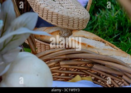 Ein lebhaftes Picknick im Herbst bietet farbenfrohe saisonale Speisen – helle Kürbisse, Äpfel, Wurstwaren, frisches Brot, Käse, und warme Getränke. Umschlossen b Stockfoto