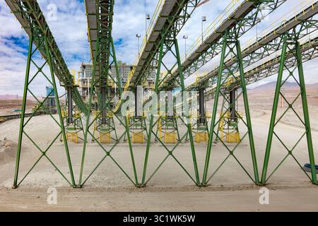 Chilenischer Kupferbergbau: Mineralerz gelangt über mehrere Förderbänder in die Zerkleinerungsanlage, ein wichtiger Schritt in der Produktion. Stockfoto