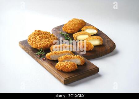 Köstliche knusprige, goldgebratene Schweinefleisch- und Schmelzkäse-Snacks auf Holzbrettern Stockfoto