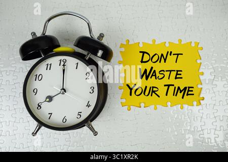 Verschwenden Sie nicht Ihre Zeit mit einem Wecker auf gelbem Hintergrund Stockfoto