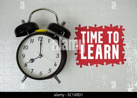 Zeit zum Lernen von Text mit Wecker auf rotem Hintergrund Stockfoto