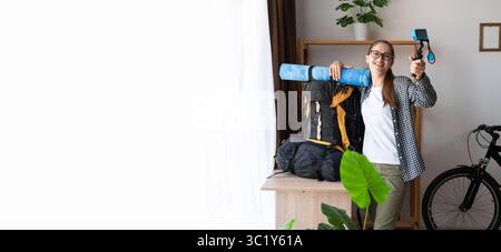 Junge Wanderer, die mit einem großen Rucksack auf Wandertour geht und ein Video mit einer Action-Kamera zu Hause aufnimmt. Banner. Kopierbereich Stockfoto