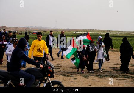 30. März 2019 - Gaza-Stadt, Gazastreifen, Palästina - palästinensische Demonstranten schwenken palästinensische Flaggen und rufen Parolen, während sie sich der Grenze zwischen Israel und Gaza nähern, am ersten Jahrestag des Großen Rückkehrprotests. (Kreditbild: © Mahmoud Issa/Quds Net News via ZUMA Wire) Stockfoto