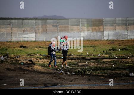 30. März 2019 - Gaza-Stadt, Gazastreifen, Palästina - palästinensische Demonstranten schwenken palästinensische Flaggen und rufen Parolen, während sie sich der Grenze zwischen Israel und Gaza nähern, am ersten Jahrestag des Großen Rückkehrprotests. (Kreditbild: © Mahmoud Issa/Quds Net News via ZUMA Wire) Stockfoto