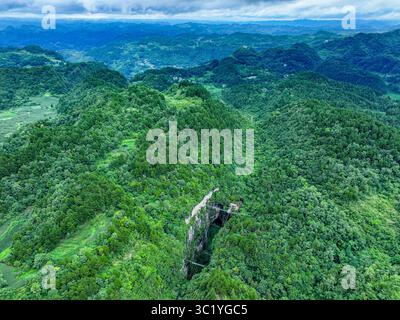 Guizhou. Juli 2025. Ein Luftbild der Drohne, aufgenommen am 22. Juli 2025, zeigt einen Panoramablick auf ein riesiges Sinkloch im Kaiyang County in der südwestlichen Provinz Guizhou. Die Provinz Guizhou ist bekannt für ihre ausgedehnte Karstlandschaft, die sich durch ihre zahlreichen riesigen Senken auszeichnet, die lokal „Tiankeng“ oder „himmlische Gruben“ genannt werden. Die natürlichen Sinklöcher werden zunehmend für ihre einzigartigen touristischen Werte anerkannt. Quelle: Ou Dongqu/Xinhua/Alamy Live News Stockfoto