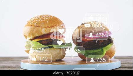 Stapeln Sie Rinderburger mit Salat, Tomaten, Käse, Zwiebeln auf Holzbrett, mit Social-Media-Ikonen Stockfoto