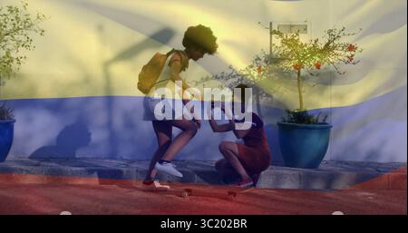 Ein Freund filmt Skateboarder mit Smartphone, Rucksack und Pflanzen auf der sonnendurchfluteten Straße Stockfoto