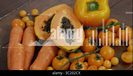 Zeigt Karotten, Papaya-Hälften, Paprika und Kirschtomaten auf Holztisch, mit Datenüberlagerungen Stockfoto
