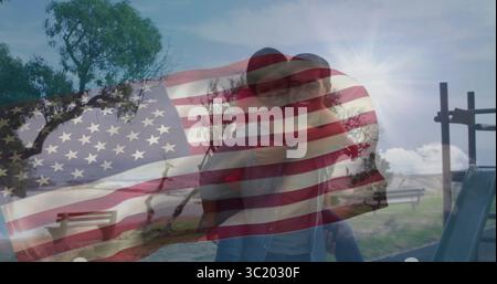 Ein Huckepack-Ride-Mann mit Partner im grasbewachsenen Park, Fahnenüberzug und Rutschleiter Stockfoto