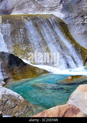 Paradiesisches türkisblaues Maggia-Flussbecken mit Wasser, das über Steine im Maggiatal im Tessin fließt Stockfoto