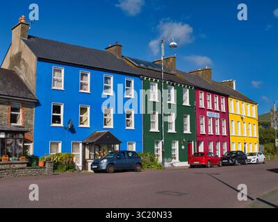 Bantry, Irland - Mai 31 2025: Eine Reihe von bunt bemalten Häusern in Bantry, Irland, schafft eine lebendige und charmante Straßenlandschaft unter einem klaren blauen Himmel. Stockfoto