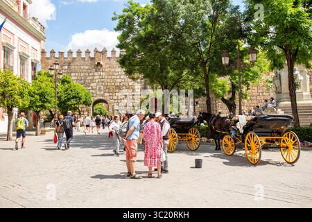 Touristen und Urlauber im Urlaub, die in der spanischen Stadt Sevilla, Spanien, außerhalb des Alcazar, reiten Stockfoto