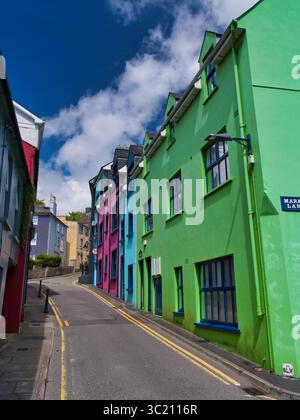 Kinsale, Irland - 28. Mai 2025: Bunte Häuser säumen eine enge Straße in Kinsale, Irland und schaffen eine lebendige und einladende Szene. Stockfoto