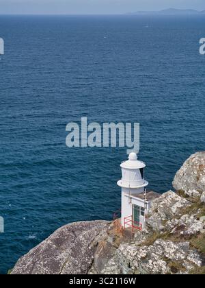 Sheeps Head, Irland - 02. Juni 2025: Ein robuster Leuchtturm steht auf zerklüfteten Klippen mit Blick auf den riesigen Atlantik in Sheeps Head, Irland. Stockfoto
