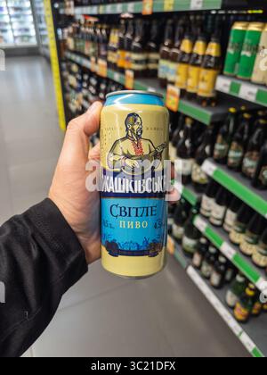 Kiew, Ukraine - 05. Juli 2025: Eine Hand hält eine Dose mit Schaschkiwske Svitle ukrainischem Leichtbier in einem Supermarkt-Biergericht Stockfoto