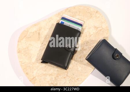 Sammlung von Ledergeldbörsen mit Kreditkarten auf weißem, beigem und Marmorhintergrund Stockfoto