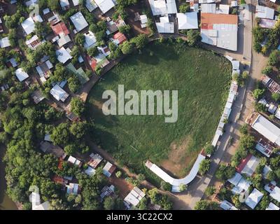 Aus der Vogelperspektive sehen Sie einen grünen Park, der von Häusern und Bäumen umgeben ist und eine ruhige Atmosphäre in der Gemeinschaft widerspiegelt. Stockfoto