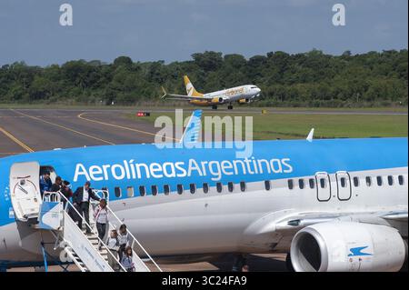 24. April 2019 - Buenos Aires, Buenos Aires, Argentinien - Fluggäste steigen von der Boeing 737-800 Next Gen-Registrierung LV-FRQ von AEROLINEAS ARGENTINAS im Flughafen IGUAZÃš in der Provinz Misiones ab als ähnliches Flugzeug startet die Registrierung LV-HFQ von der Billigfluggesellschaft FLYBONDI. Der Flughafen ist aufgrund der nahe gelegenen IGUAZÃš-FÄLLE ein beliebtes Reiseziel für internationale Touristen. In diesem Jahr werden rund eineinhalb Millionen Passagiere befördert und Direktflüge von Europa aus angeboten. (Bild: © Patricio Murphy/ZUMA Wire) Stockfoto