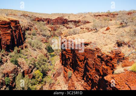 Rote Felsklippen und karge Vegetation prägen den Karijini-Nationalpark, Australien. Stockfoto