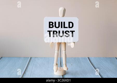 Vertrauenssymbol aufbauen. Weißes Puzzle mit Worten schafft Vertrauen. Schöner rosafarbener Hintergrund. Business-Konzept und Vertrauensaufbau. Kopierbereich. Stockfoto