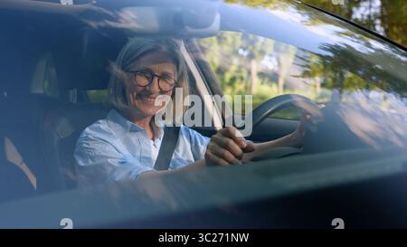 Erfolgreiche kaukasische lächelnde ältere Geschäftsfrau reife Geschäftsfrau Autofahrer Autohalter Mietwagenkunde sitzen in einem neuen Fahrzeug Stockfoto