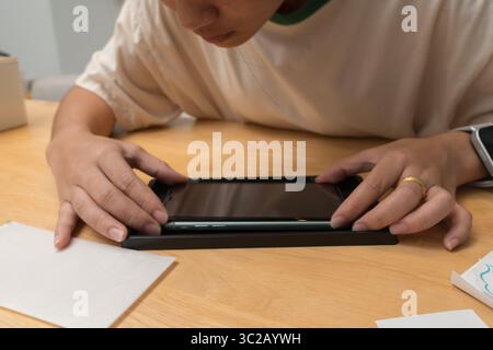 Nahaufnahme der Person, die die Ausrichtung während des letzten Schritts der Installation des Schutzschirms aus gehärtetem Glas am Smartphone überprüft. Viel Liebe zum Detail Stockfoto