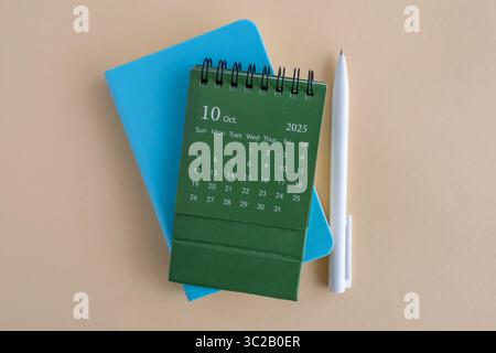 Hallo, Oktober 2025. Desktop-Kalender und Notizblock zum Schreiben auf dem Desktop Stockfoto
