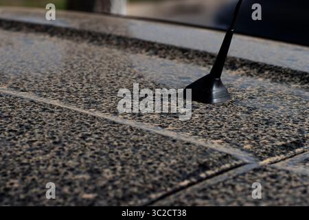 Nahaufnahme von gelbem Sahara-Sand und Regen auf einem schwarzen Auto Stockfoto