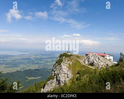 Das große Kreuz auf dem Gipfel von Bergen mit Blick über den Chiemsee. Deutschland. Stockfoto