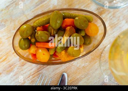 Grüne Oliven serviert mit Gurke, Karotte, Knoblauch und Zwiebeln Stockfoto